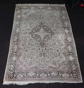 A white and blue ground, floral patterned Qam style, Persian silk carpet with star shaped medallion to the centre within a multi row border 274cm x 179cm 