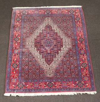 A red, white and blue ground North Persian rug with diamond shaped medallion to the centre, 150cm x 119cm 