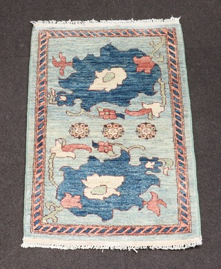 A green and blue ground Chinese rug decorated leaves 97cm x 66cm 