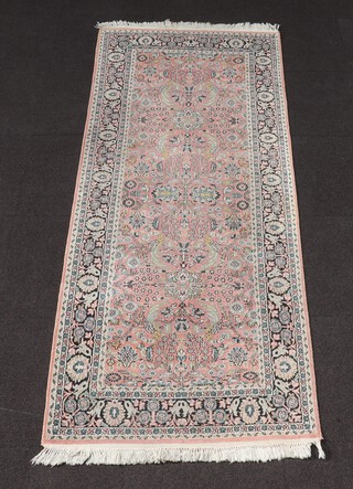 A pink, white and blue ground Persian runner with floral medallion to the centre within a multi row border, 238cm x 92cm 