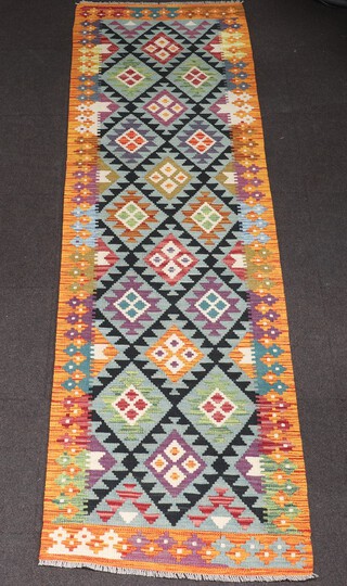 An orange, green and black ground Maimana Kilim runner with all over geometric design 304cm x 84cm 