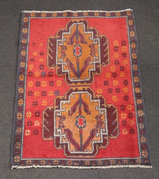 A red and brown ground Belouche rug with 2 medallions to the centre 131cm x 93cm 