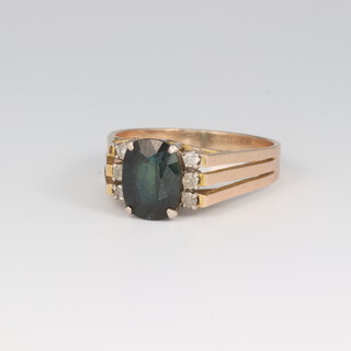 An 9ct yellow gold oval tourmaline ring 1.5ct flanked by 6 brilliant cut diamonds 0.06ct, size N, 3.2 grams 