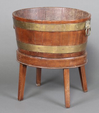 A Georgian oval coopered mahogany cellarette with brass lion mask handles, raised on an associated stand 62cm h x 66cm w x 48cm d 