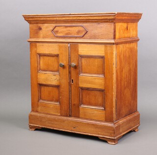 A 19th Century cedar table top cigar cabinet with moulded cornice, fitted shelves enclosed by panelled doors, raised on bracket feet 52cm h x 46cm w x 25cm d 