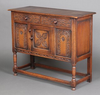 A 17th Century style carved oak hutch cabinet fitted 2 drawers above cupboard, enclosed by panelled doors, raised on turned and block supports 87cm h x 105cm w x 42cm d 