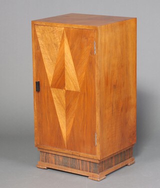 An Art Deco pedestal cabinet with quarter veneered top and panelled door to the front decorated a diamond, the interior fitted 2 trays, raised on bracket feet 93cm h x 48cm w x 42cm d 