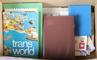 A collection of first day covers, stamps on paper, etc, contained in a cardboard box 