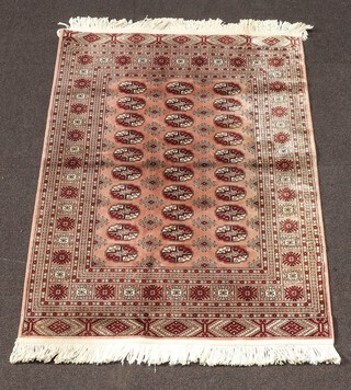 A machine made brown and white ground Bokhara style rug with 30 octagons to the centre 136cm x 98cm 