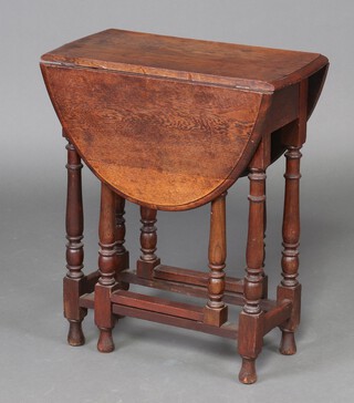 A 1930's oak oval drop flap tea table, raised on turned supports 70cm h x 61cm w x 29cm d 