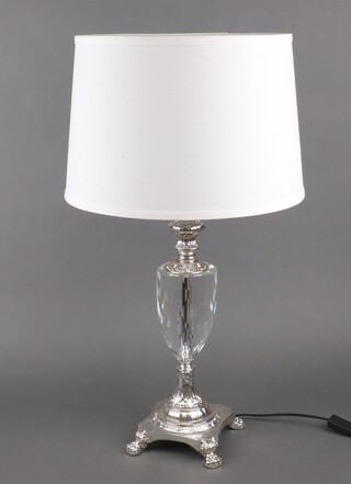 A faceted glass and silver effect table lamp complete with shade on a platform base with paw feet 40cm x 15cm 