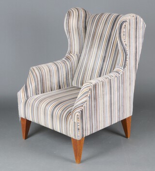 A Georgian style winged armchair upholstered in striped material, raised on square supports 110cm h x 75cm w x 70cm d  
