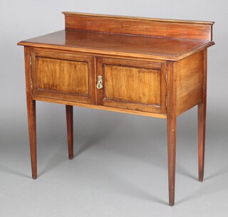 An Edwardian mahogany wash stand with raised back, the base enclosed by panelled doors, raised on square tapered supports 85cm h x 91cm w x 45cm d 