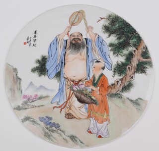 A circular Chinese porcelain plaque depicting a standing gentleman with attendants with distant hills and script 26cm 