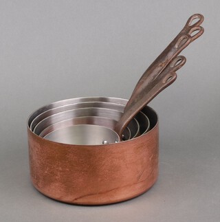 Five coppered graduated saucepans 