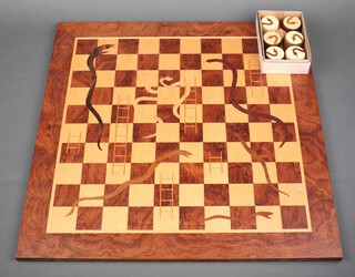 A hardwood snakes and ladders board with counters 