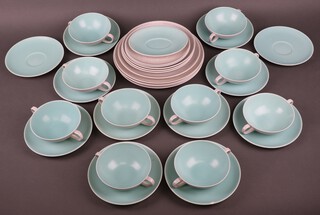 A mid-Century Poole Pottery service comprising 10 two handled bowls, 12 saucers, 6 medium plates, 4 dinner plates and an oval saucer
