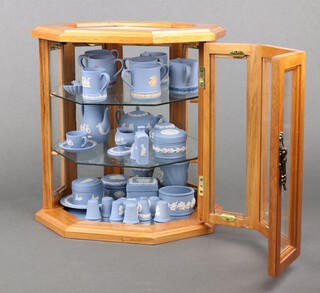 An octagonal table top display cabinet containing a collection of miniature pale blue Jasperware china 