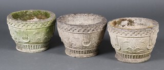 Three well weathered circular concrete garden urns, bodies cast drop handles 24cm h x 34cm diam. 