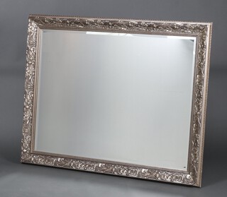 An Art Nouveau style bevelled plate wall mirror contained in a decorative silvered frame 138cm x 107cm 