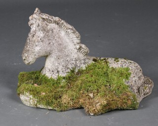 A well weathered concrete garden figure of a seated horse