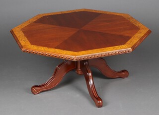 A Georgian style octagonal crossbanded mahogany coffee table, raised on a turned column and outswept supports 46cm h x 96cm w x 96cm d 