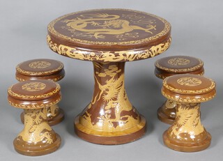 A circular Japanese brown and gold glazed pottery garden set comprising pedestal table 73cm h x 78cm diam. and 4 pedestal stools 40cm x 33cm diam., decorated dragons 