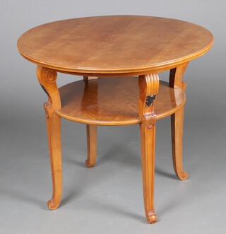 A 1920's circular Continental walnut 2 tier occasional table, raised on outswept supports 72cm h x 85cm diam. 