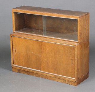 An oak Minty style 2 tier bookcase the 2 top tiers enclosed by glazed panelled doors, the base enclosed by oak panelled doors 76cm h x 89cm w x 29cm d 