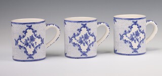 Three Tiffany and Co, Tiffany Delft mugs decorated with panels of flowers 10cm 