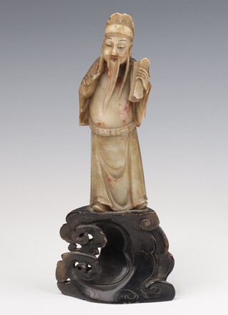 A carved soapstone figure of a scholar holding a scroll on a carved soapstone base 20cm 
