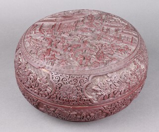 A 19th century Chinese circular cinnabar lacquer box, the top decorated courtly figures, the sides with floral panels, the base with gilt 6 character mark 17cm x 31cm 