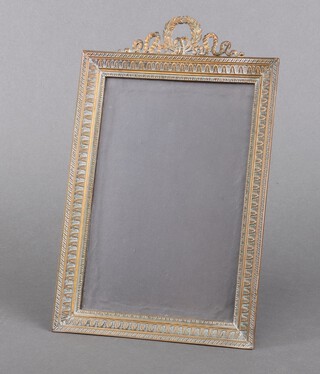 A 19th Century Empire style brass easel photograph frame, the top surmounted by a leaf and ribbon garland 27cm h x 16cm w  