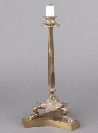 A Regency gilt bronze reeded candlestick with leaf and paw supports on a triform base 34cm x 18cm 
