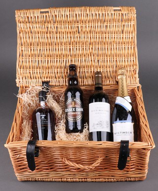 A wicker hamper containing a bottle of 2016 Chateau Haut Maginet Bordeaux red wine, a bottle of Nyetimber Classic Cuvee, a bottle of Quinta de al Rosa 20 year old tawny port and a bottle of Arundel brewery dark ale 