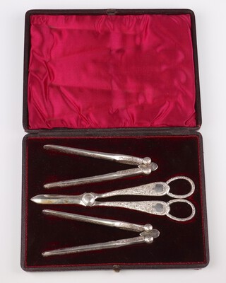 An Edwardian cased silver plated set of grape scissors and nut crackers with engraved floral decoration 