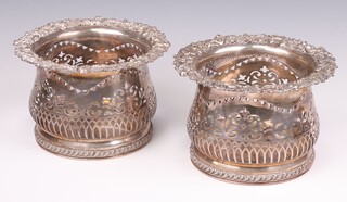A pair of 19th Century baluster shaped silver plated wine coasters with scroll and floral rims and pierced bodies 13cm 