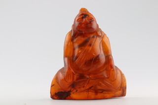 An 18th/19th Century carved Chinese amber figure of a seated deity 5cm, 14.1 grams (with many visible inclusions)