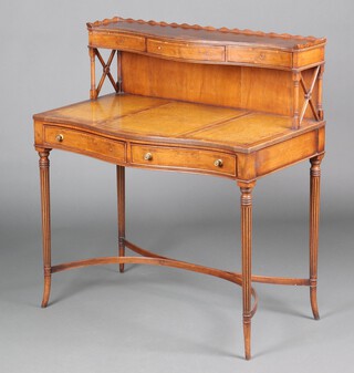 A Georgian style bow front yew writing table, the back with raised super structure fitted 3 short drawers above green inset writing surface, the base fitted 2 drawers, raised on turned and fluted supports with Y shaped stretcher 101cm h x 92cm w x 52cm d  