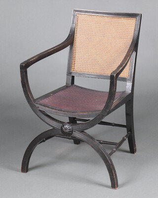 A Georgian style ebonised open arm chair with single woven cane back and upholstered seat, raised on an X framed support 88cm h x 58cm w x 54cm d (seat 25cm x 30cm) 