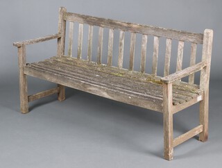 A well weathered slatted hardwood garden bench 81cm h x 157cm w x 53cm d 