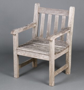 A well weathered slatted hardwood garden open arm chair 86cm h x 56cm w x 58cm d 