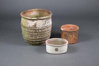 A well weathered circular terracotta planter with ring decoration 48cm h x 49cm diam. (frost damage), a circular terracotta plant pot 23cm x 29cm and a white glazed boat shaped terracotta pot 15cm x 33cm x 25cm 