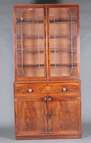 A Georgian mahogany secretaire bookcase, the upper section fitted adjustable shelves enclosed by astragal glazed panelled doors, the well fitted secretaire drawer with drawers and pigeon holes, above a shelved cupboard enclosed by a pair of panelled doors, raised on a platform base 248cm h x 124cm w x 57cm d 