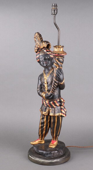 A painted plaster table lamp in the form of a standing liveried servant holding a torch 68cm h x 23cm 