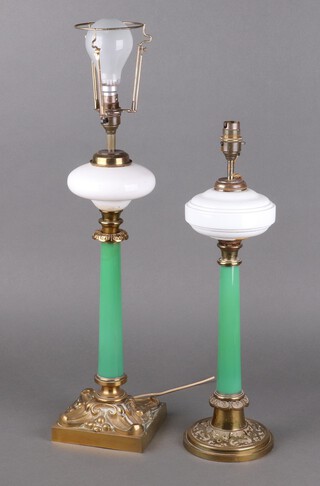 A 19th Century gilt metal and green glass oil lamp base with opaque glass shade, converted for use as an electric light, raised on a square base 46cm x 15cm, together with a similar lamp 43cm x 14cm  