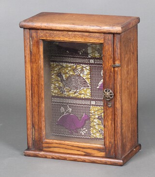 A 1930's oak table top display cabinet enclosed by a glazed panelled door 39cm h x 30cm w x 16cm d 