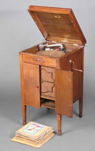 An Academy Standard gramophone contained in an oak cabinet with hinged lid, on square supports 86cm h x 47cm w x 42cm d together with a collection of 78rpm records 