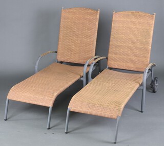 A pair of metal framed plastic rattan adjustable garden loungers 30cm h x 192cm l x 63cm w 