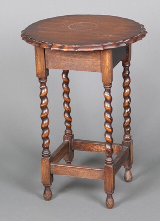 A 1930's circular oak occasional table with pie crust edge, raised on spiral turned supports 71cm x 50cm (ring and contact marks in places)